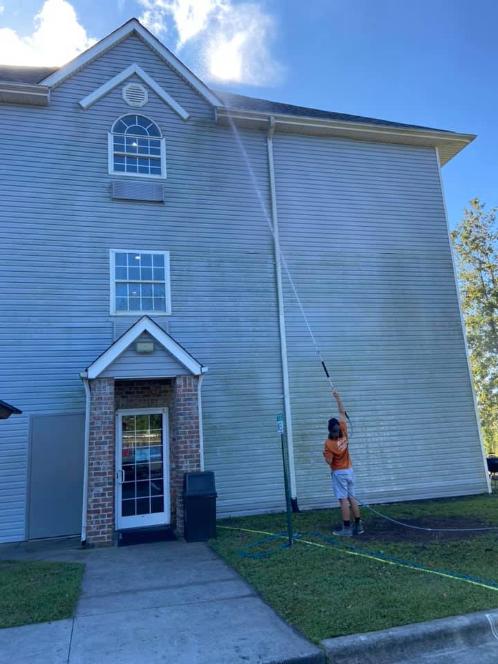 Southern Coast professionals cleaning siding on white home